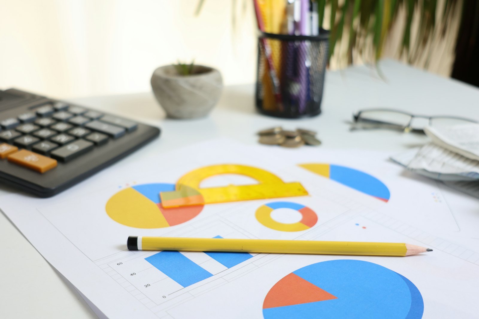 Business mathematics study desk with charts, calculator and pencil